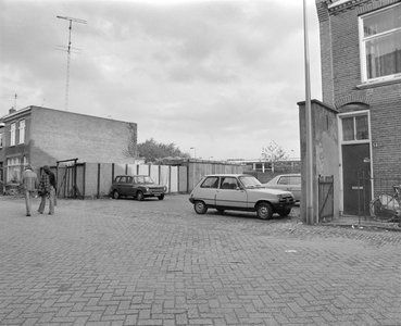 882122 Gezicht op een braakliggend terrein aan de Helling te Utrecht, dat tijdelijk in gebruik is als parkeerterrein, ...